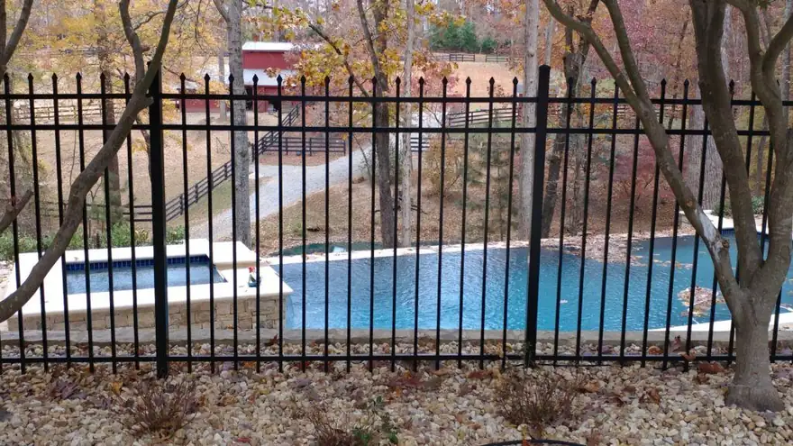 Black spear-top aluminum fence installed beside a backyard pool in Brookhaven, GA