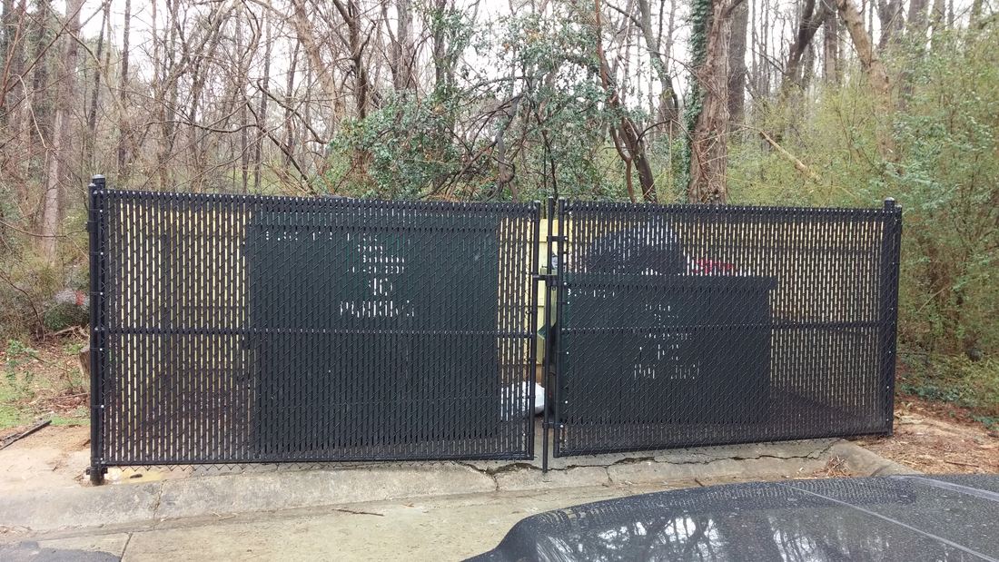 Black chain link dumpster enclosure with gates