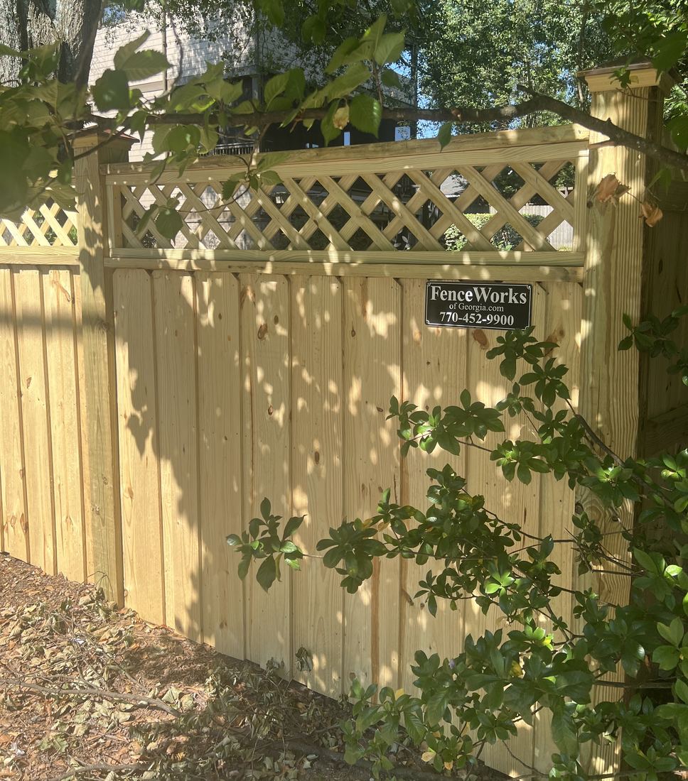 Capped wood privacy fence with lattice top and post caps