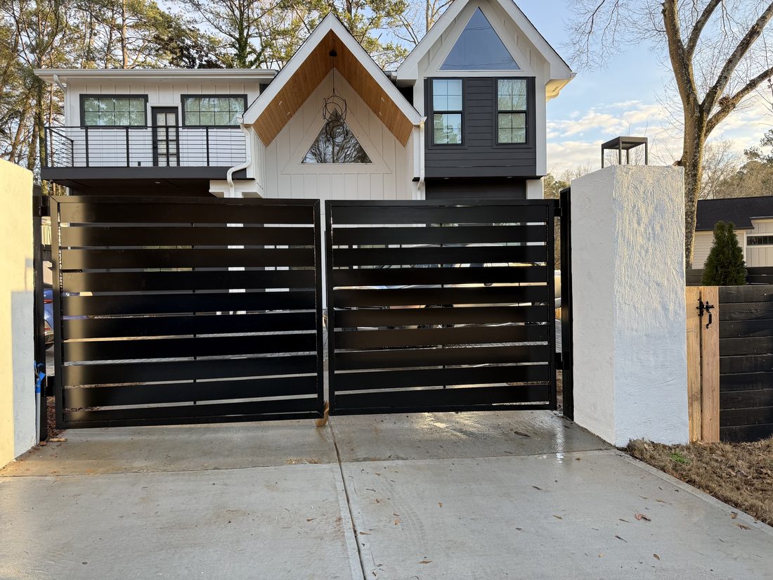 Custom black horizontal-slat aluminum dual-swing driveway gate at a modern Decatur, GA home, built by FenceWorks of Georgia