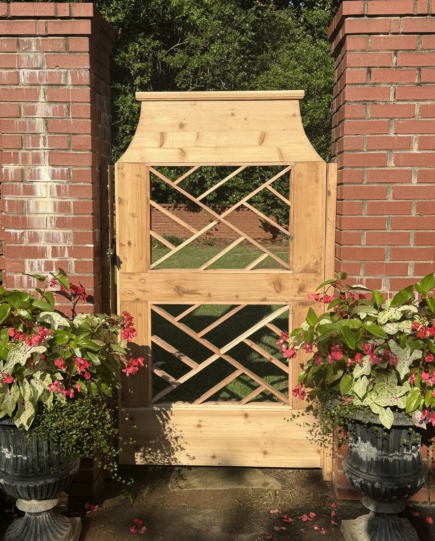 Custom-built wood Chippendale lattice walk gate set between brick columns