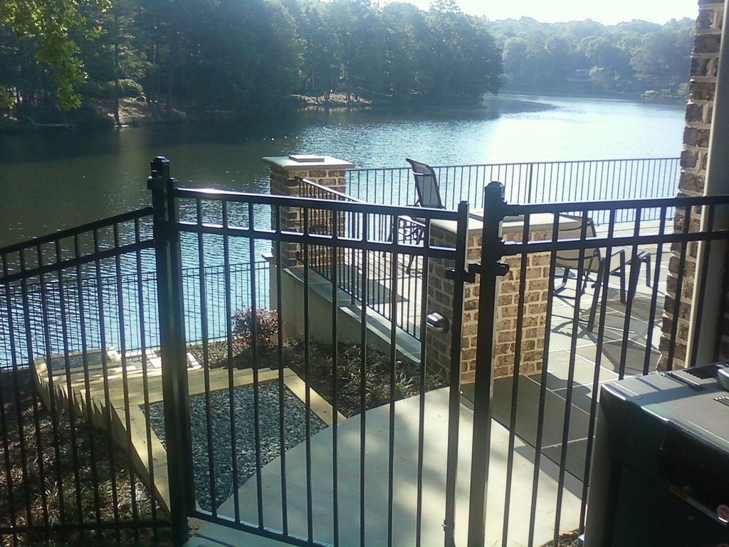 Ornamental metal flat-top fence set between stone columns, installed by FenceWorks of Georgia