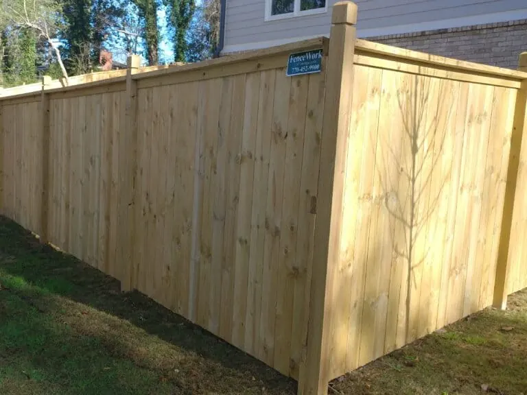 Capped wood privacy fence in a residential backyard