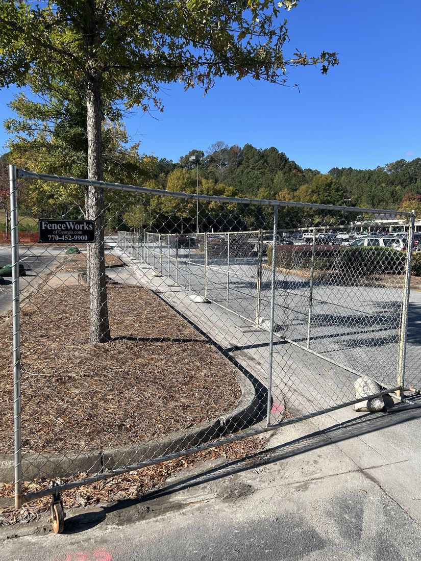 Temporary chain link panel fence securing a commercial parking lot job site in metro Atlanta