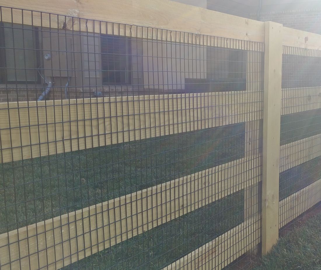Wood four-rail ranch rail fence with pool-compliant welded wire