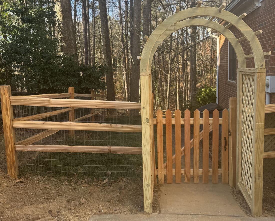 Wood split rail fence with a rooftop arbor and picket walk gate