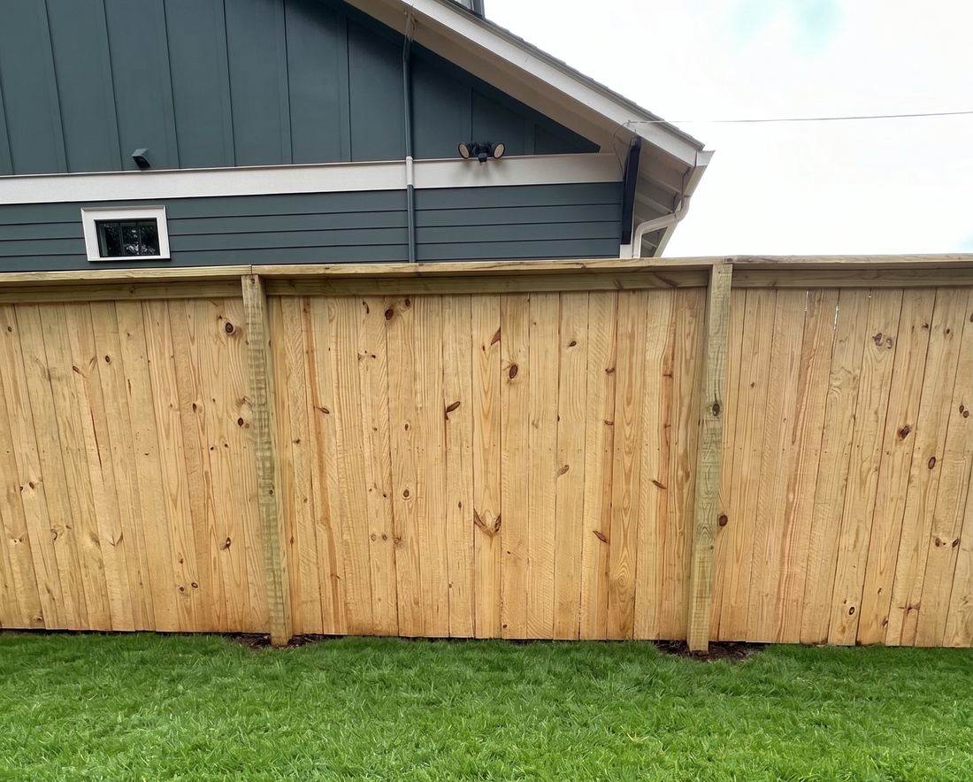 Capped wood privacy fence with a flat-top rail along a residential yard, built by FenceWorks of Georgia