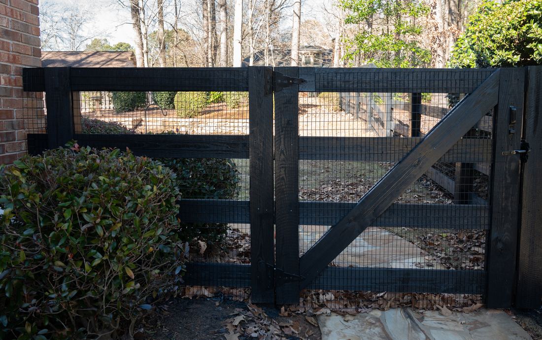 Wood four-rail ranch rail fence with a wire-infill gate